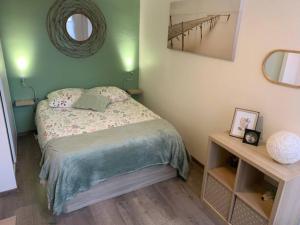 a small bedroom with a bed and a mirror at Etape saumuroise en centre-ville in Saumur