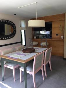 tavolo da pranzo con sedie rosa e cucina di Casa Las Margaritas a San Carlos de Bariloche