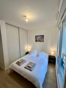 ein Schlafzimmer mit einem weißen Bett und Handtüchern darauf in der Unterkunft Ideal family flat in st-ouen in Saint-Ouen