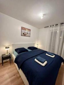 Un dormitorio con una cama azul con toallas. en Ideal family flat in st-ouen en Saint-Ouen