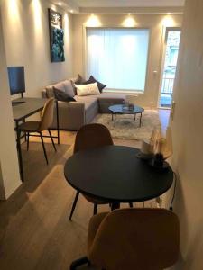 - un salon avec un canapé, une table et des chaises dans l'établissement Sørenga MUNCH ved kanalen - egen terrasse uteplass, à Oslo