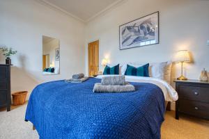 a bedroom with a large bed with a blue blanket at 2-BR Stunning Apt, Sleeps 6, Near Ocean Village, Parking by Blue Puffin Stays in Southampton
