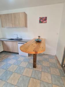 una mesa de madera en medio de una cocina en Kami lodge f3 jacuzzi en Rivière-Salée