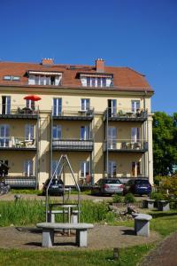 einen Spielplatz vor einem großen Gebäude in der Unterkunft Einraumapartment mit Seeblickbalkon in Rheinsberg