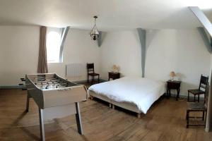 een slaapkamer met een bed en een tafel en stoelen bij Le Logis de Louis in Saint-Savin