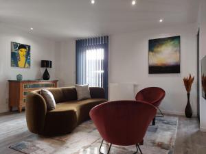 Urbs Amiens Sud في أميان: غرفة معيشة مع أريكة وكرسيين