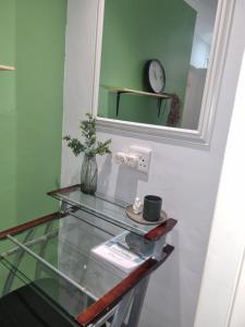 una mesa de cristal con espejo y un reloj en la pared en Eland Place Self Catering Guest House, en Beacon Bay 54 fotos más