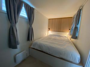 une petite chambre avec un lit et une fenêtre dans l'établissement Entire renovated apartment from 1780 with Kitchen, Bath, Bedroom, and Living Room in Skuteviken, à Bergen