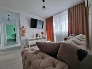 een woonkamer met een bank en een flatscreen-tv bij Palace Hils in Boekarest