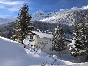 a building in the snow with trees and mountains at Appartment 1500 m an der Seilbahnstation in Uttendorf