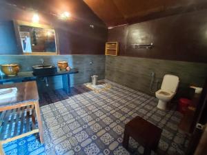 a bathroom with a toilet and a sink at Sea Front Cottage Little Khola in Cola