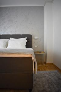 a bedroom with a large bed with a gray wall at BorLu apartman in Đakovo
