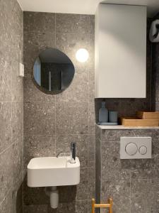 a bathroom with a white sink and a mirror at Renovated apartment from 1780, located in heritage site (Skuteviken) in Bergen