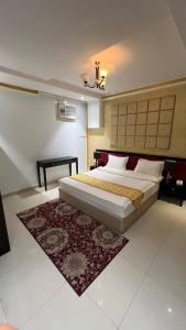 a bedroom with a large bed and a rug at Ark Chalet in Hail