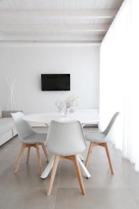 ein weißes Esszimmer mit einem weißen Tisch und Stühlen in der Unterkunft Bottego24 Suite, Apartment & Terrace in Nardò