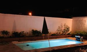 ein Schwimmbad vor einer Wand in der Nacht in der Unterkunft Hermosa y Amplia Casa Familiar en Alta Gracia in Alta Gracia