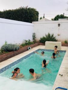 eine Gruppe von Personen, die in einem Schwimmbad schwimmen in der Unterkunft Hermosa y Amplia Casa Familiar en Alta Gracia in Alta Gracia
