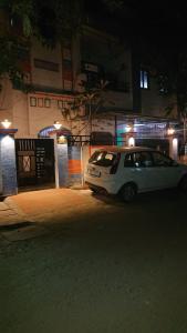 ein weißes Auto, das nachts auf einer Straße parkt in der Unterkunft Leisure Homestay in Udaipur