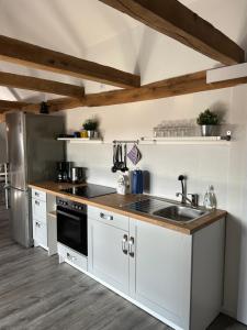 a kitchen with white cabinets and a stainless steel refrigerator at Zur Scheune in Bad Wildungen