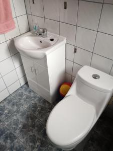 uma casa de banho com um WC branco e um lavatório. em Residencial familiar em Puerto Montt