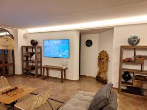 sala de estar con sofá y TV en la pared en laCelletta Country House, en Urbino