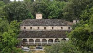 a large stone building with a tower on top of it at Dhimitrulla Guest-House in Përmet