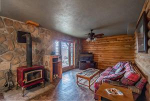 a living room with a fireplace and a stone wall at Buffalo River Lodge (Yellville)- Lower Level in Saint Joe