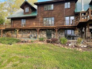 a large wooden house with a large deck at Buffalo River Lodge (Yellville)- Lower Level in Saint Joe