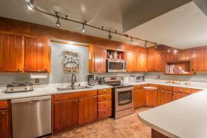 a kitchen with wooden cabinets and white counter tops at Buffalo River Lodge (Yellville)- Lower Level in Saint Joe