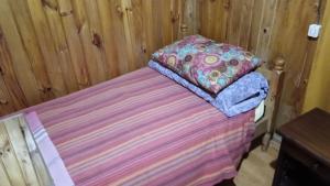 Cama con colcha a rayas y almohada en Residencial familiar, en Puerto Montt