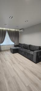 - un salon avec un grand lit dans une chambre dotée de parquet dans l'établissement The Velvet, à Chişinău