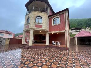 a house with a clock tower on top of it at Quba Villa in Uçgün