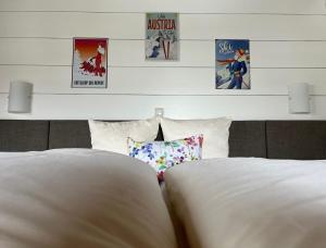 a bedroom with two white beds and posters on the wall at Nonas B&B in Galtür