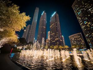 einen Brunnen vor einer Stadt in der Nacht in der Unterkunft The Address Residences Dubai Opera, Full Burj Khalifa View, Luxurious 2BR in Dubai