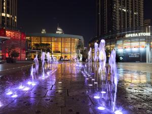 杜拜的住宿－The Address Residences Dubai Opera , Full Burj Khalifa View , Luxurious 2BR，夜间在建筑物前的喷泉