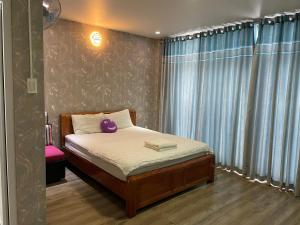 a small bedroom with a bed and a window at Red Bean Hotel in Thuan An