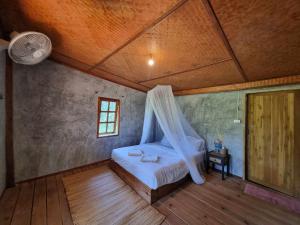 een slaapkamer met een bed met een klamboe bij Nongtao homestay in Ban Dong Than