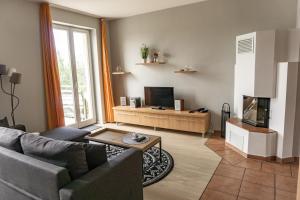 a living room with a couch and a tv at Apartmenthaus am Grienericksee in Rheinsberg