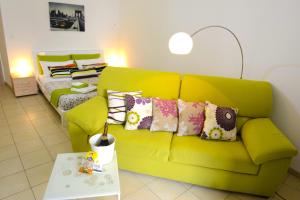 sala de estar con sofá verde y cama en B&B Affittacamere Del Teatro, en Brindisi