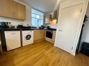 a kitchen with a washer and dryer in it at Chamber Apart City Centre BD1 in Bradford