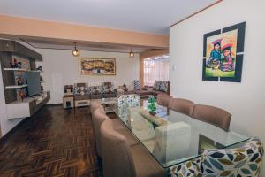 a living room with a glass table and chairs at PAKARINA HOUSE in Cusco