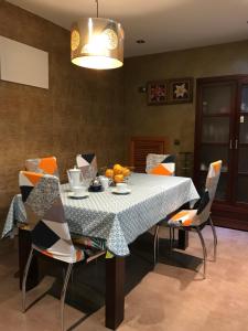 una sala da pranzo con tavolo, sedie e lampadario di Casa bien Situada Chez Mahinna a Cehegín