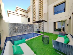 a backyard with a swimming pool and green grass at Penthouse with Private Pool and Big Private Terrace in Dubai