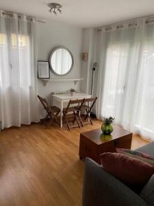 ein Wohnzimmer mit einem Tisch, Stühlen und einem Sofa in der Unterkunft Apartamento con jardín en Costa Quebrada in Liencres