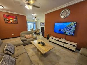 een woonkamer met een grote flatscreen-tv bij Ibranad Apartments in Accra