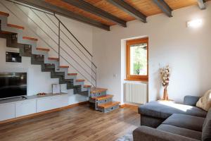 a living room with a couch and a staircase at REVO Apartments - Cà Berti in Teglio