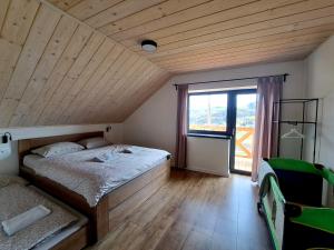 a bedroom with a bed and a large window at U Hanky pod Hrbkom in Repište