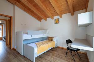 a bedroom with two bunk beds and a chair at REVO Apartments - Cà Berti in Teglio