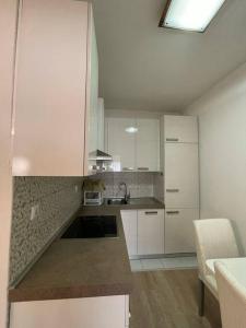 een keuken met witte kasten en een aanrecht bij Central City Apartment in Pristina