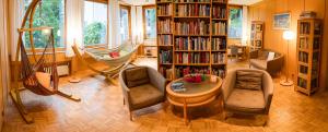 a living room with a book shelf filled with books at Panoramahotel Wagner - Das Biohotel am Semmering in Semmering